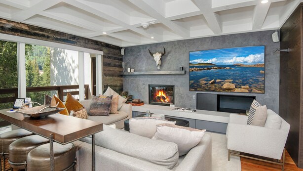A modern living room with a fireplace, a large TV, and a stone wall. - Steps to Lionshead Gondola in Vail, TT4C (Vail)