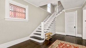 A staircase with white railings and dark steps, leading to a door with a white frame. - Spacious housing for traveling professionals (Kansas City)