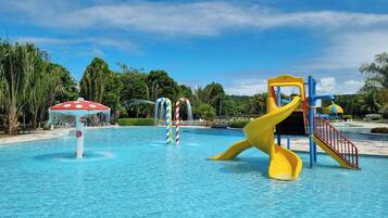 A water park with a yellow slide and a water fountain.