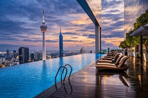 An infinity pool with a city skyline view, including a tall tower and a modern building. - Sidemen Suites at Platinum KLCC (Kuala Lumpur)