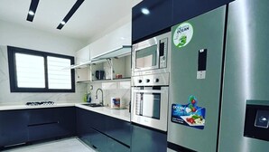 A modern kitchen with stainless steel appliances, a gas stove, and a built-in oven. - Luxurious and cosy lodge in Dakar-Alamadies with private pool (Dakar)
