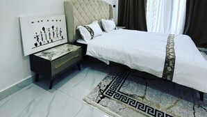 A modern bedroom with a bed, nightstand, and wall art. - Luxurious and cosy lodge in Dakar-Alamadies with private pool (Dakar)