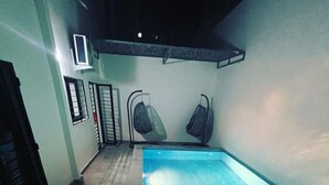 A swimming pool with a tiled floor and two wall-mounted fans. - Luxurious and cosy lodge in Dakar-Alamadies with private pool (Dakar)