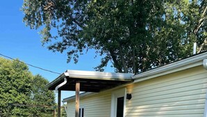 A single-story mobile home with a wooden deck, a covered porch, and a front door. - The Blue Door Place
 (Florence)