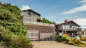 Una casa moderna de dos pisos con un garaje grande y un balcón.