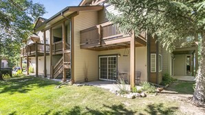 A two-story house with a covered patio, a staircase, and a small outdoor seating area. - 901 Crazy Horse Circle 2 Bedroom Condo by RedAwning (Edwards)