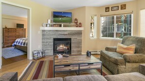 A living room with a fireplace, a television, and a comfortable seating area. - 901 Crazy Horse Circle 2 Bedroom Condo by RedAwning (Edwards)