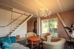 Una sala de estar moderna con una escalera, una araña y vistas al exterior.