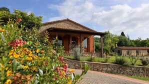 A stone building with a tiled roof, surrounded by greenery and a paved area. - La moraiola - Characteristic Tuscan barn (Toscana)