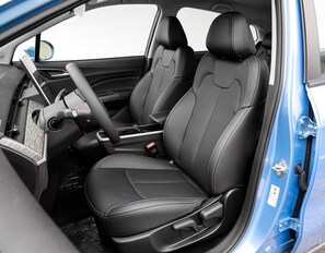 Interior de coche con asientos de cuero negro, volante y consola central.