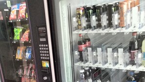 Ein Getränkeautomat mit Coca-Cola und verschiedenen anderen Getränken.
