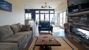 A modern living room with a sofa, a coffee table, and a stone fireplace.
