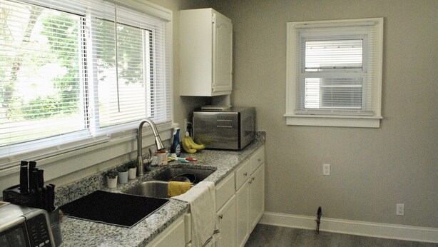 A kitchen with a sink, countertop, and cabinets.