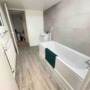 A bathroom with a bathtub, a sink, and a toilet. - London Apartment - Near King’s Cross St Pancreas! (Greater London)