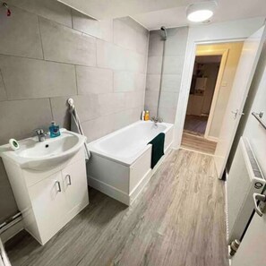 Un baño con lavamanos, bañera y ducha.