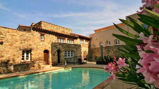 A stone building with a swimming pool, arched windows, and a tiled roof. - Heerlijk Vakantiehuis Les Pennes 4 met 3 Slaapkamers, Zeer Groot Privé Terras (Le Plan-de-la-Tour)