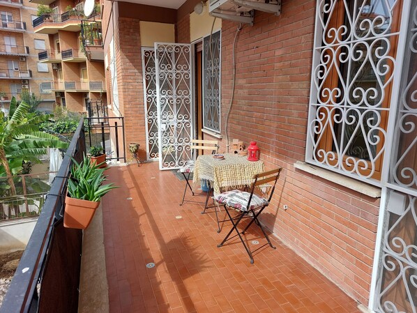 Enjoy a tranquil retreat with a balcony featuring a tiled floor, table, chair, and potted plants.