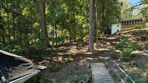 A wooden dock leading to a small bridge over a stream, with a vehicle parked nearby. - Lake front 2.5 miles from Clemson  with private cove  (Central)