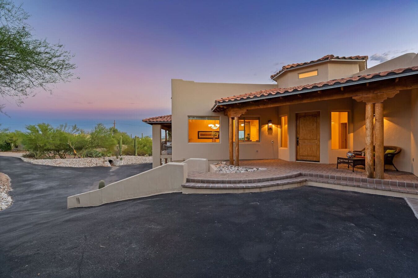 A modern house with a patio, a covered porch, and a driveway.