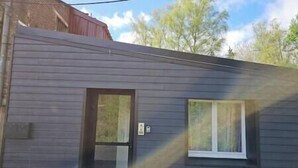 Un edificio moderno con fachada oscura, una puerta y un ventanal.