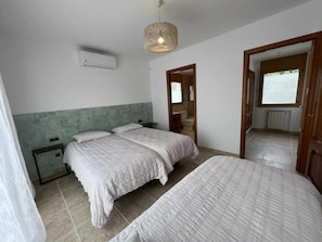 A bedroom with two beds, a ceiling fan, and a window. - Villa Cabañas with infinity pool, gardens and barbecue in Calonge, Costa Brava (Calonge)