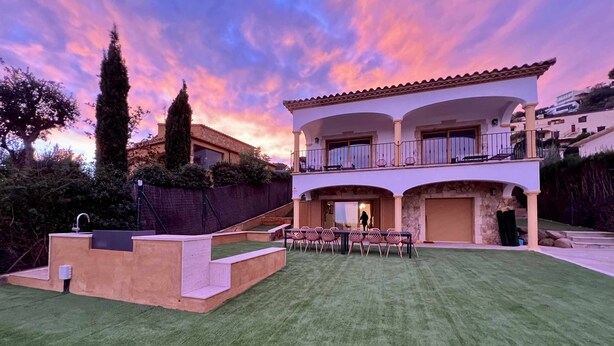 A two-story house with a balcony, a swimming pool, and a well-maintained lawn. - Villa Cabañas with infinity pool, gardens and barbecue in Calonge, Costa Brava (Calonge)