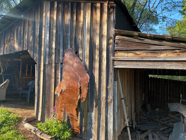 Un edificio rústico de madera con un gran cuero de animal, desgastado por el tiempo, en el lateral.