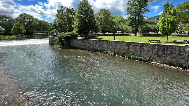 A riverside park with stone walls, picnic tables, and trees. - Stylish, Historic PSU-themed Apt.—2 blocks from Waterfront (Bellefonte)