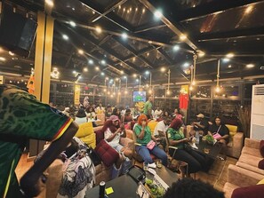 Un espace intérieur bondé, doté de plusieurs coins salon, notamment des canapés et des tables.