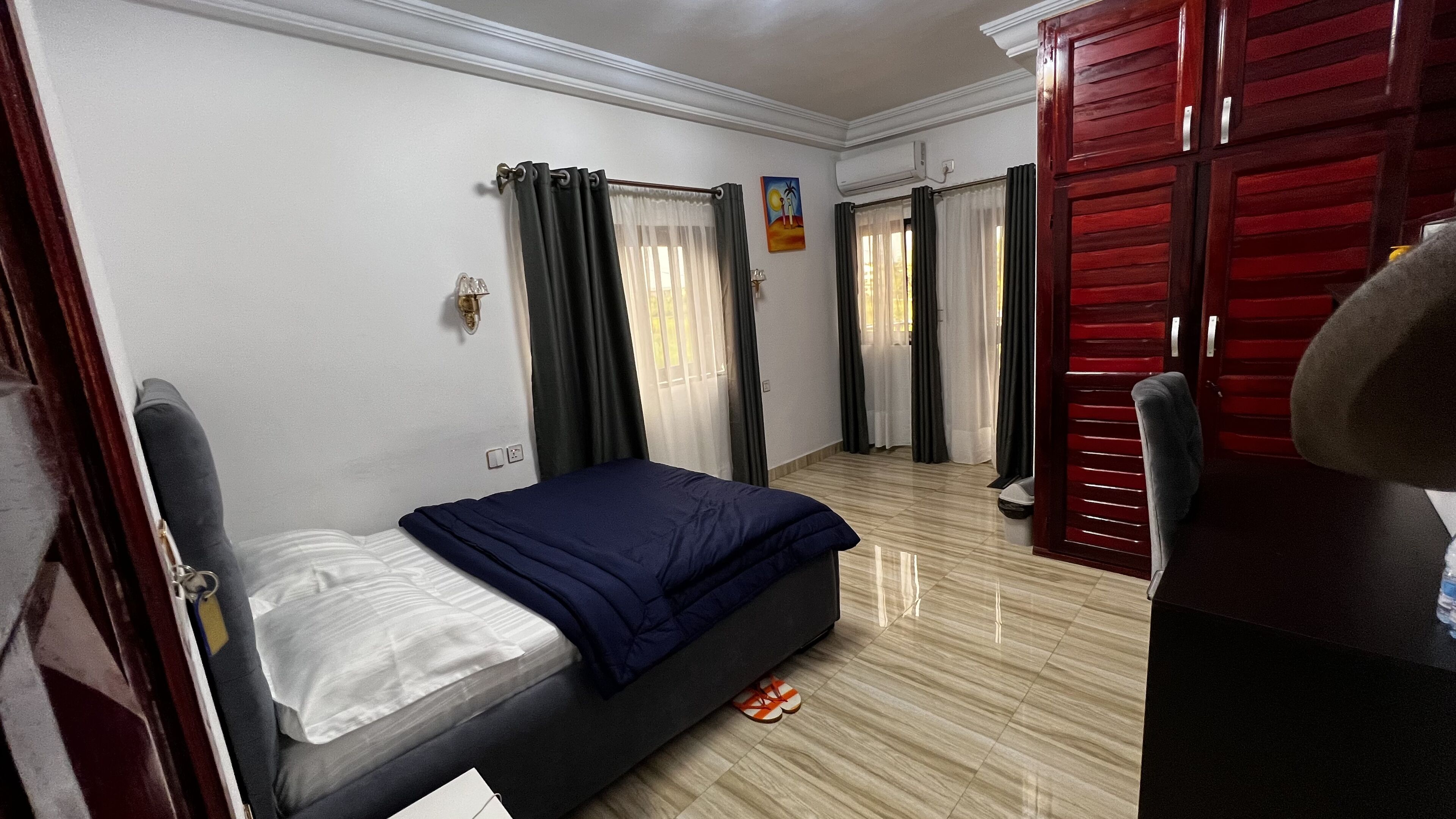 Une chambre d’hôtel avec un lit, une armoire, un bureau et une chaise.