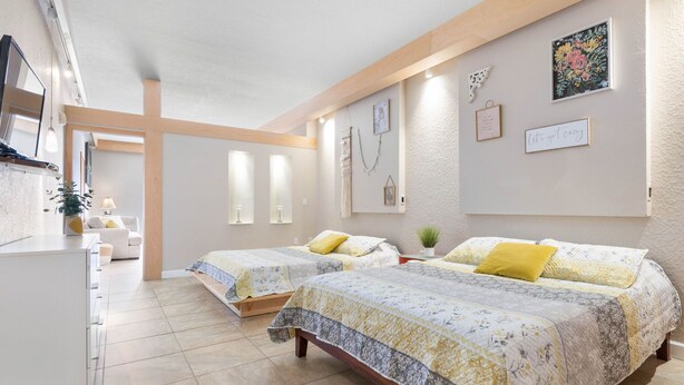 Ein Schlafzimmer mit zwei Betten, einem Schreibtisch und einem Stuhl.
