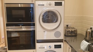 A compact kitchen with a Siemens oven, a built-in washer, and a toaster.
