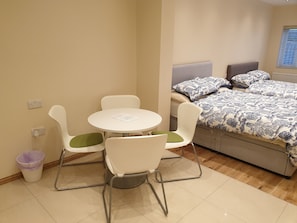 Relax in this cozy space with a comfortable bed and a compact table for two.
