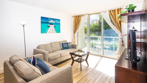 Una sala de estar con un sofá, una mesa de centro y un mueble para televisor.