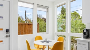 Eine moderne Küche mit Essbereich, großen Fenstern und Blick ins Freie.
