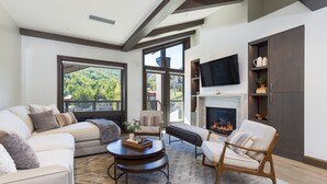 Una sala de estar moderna con chimenea, ventanas amplias y una zona de estar acogedora.