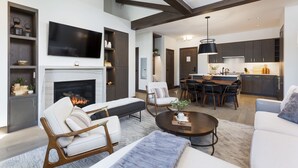 Una sala de estar moderna con chimenea, un comedor y una cocina.