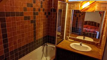 Un baño con bañera, lavamanos y espejo.