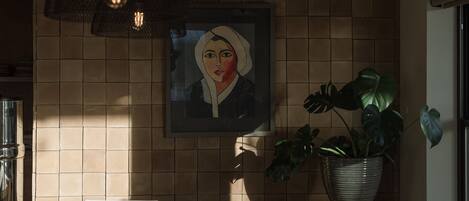 Een moderne keuken met een betegelde spatwand, hanglampen, een potplant en een lijstwerk aan de muur.
