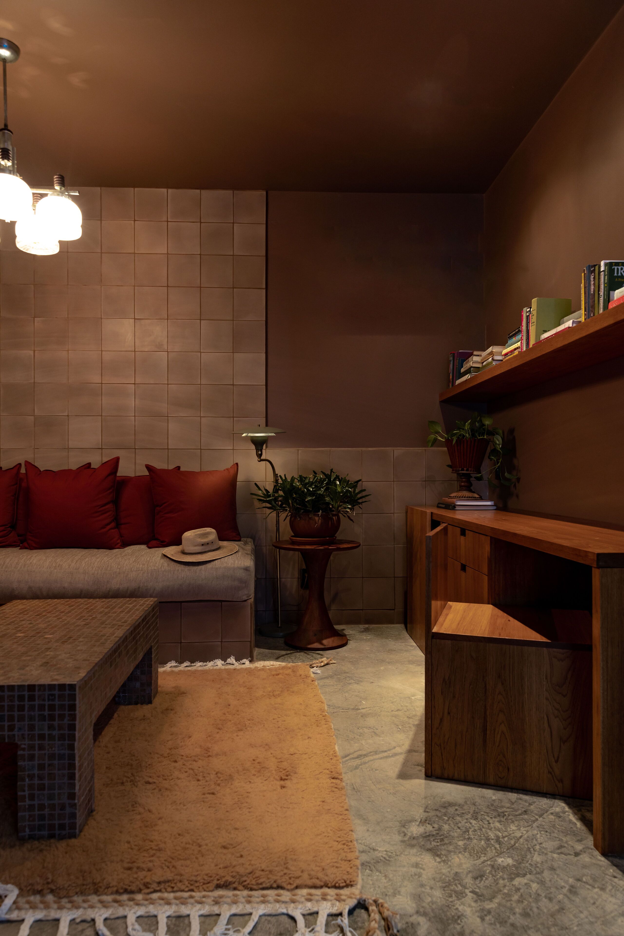 A cozy living area with a sofa, a coffee table, a lamp, and a bookshelf.