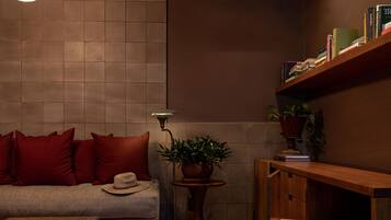 A cozy living area with a sofa, a coffee table, a lamp, and a bookshelf.