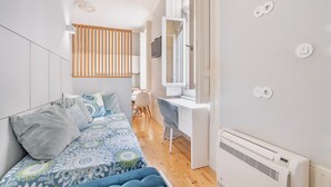 Een slaapkamer met een bed, een bureau en een stoel.