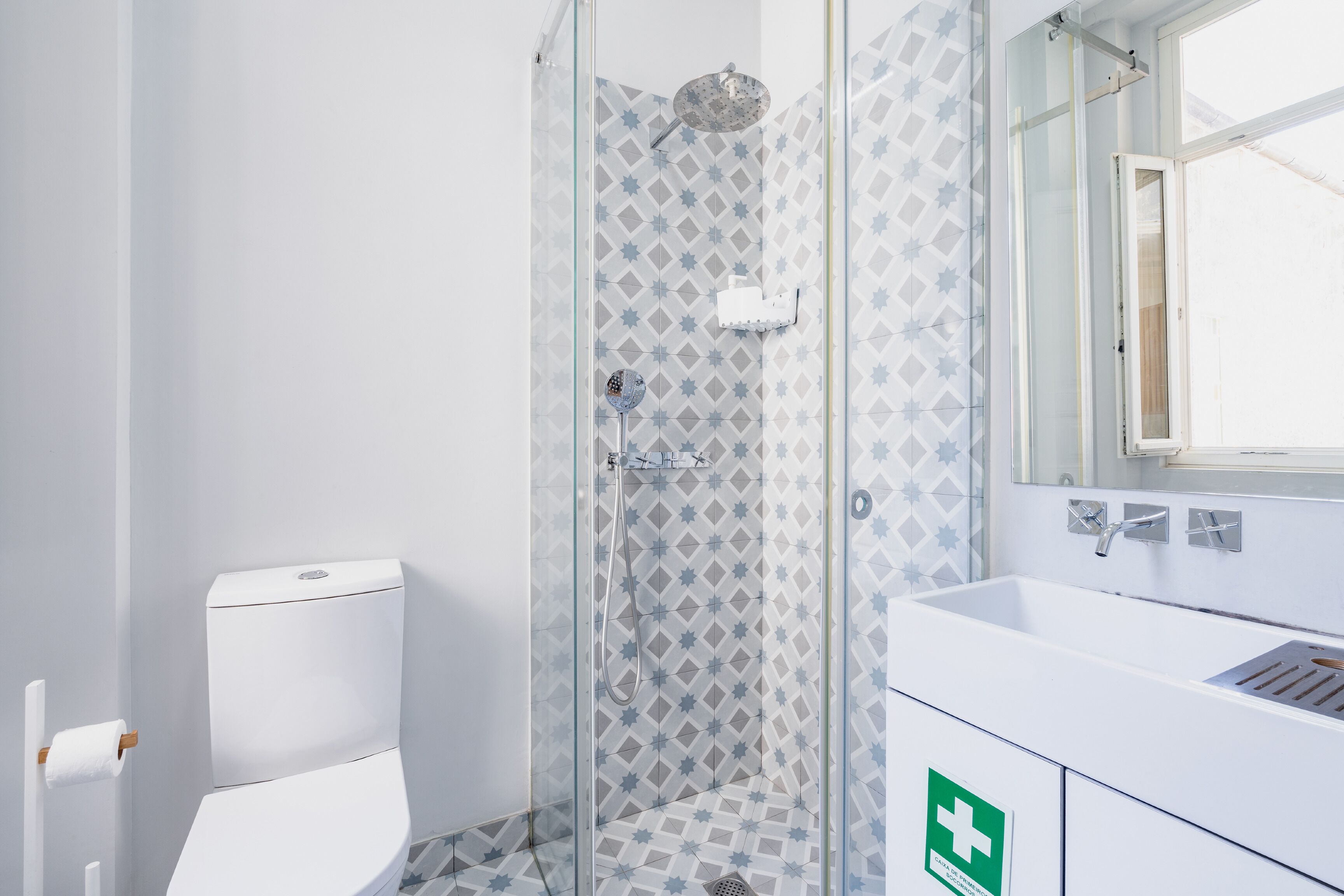 Un bagno con doccia vetrata, lavandino bianco e water.