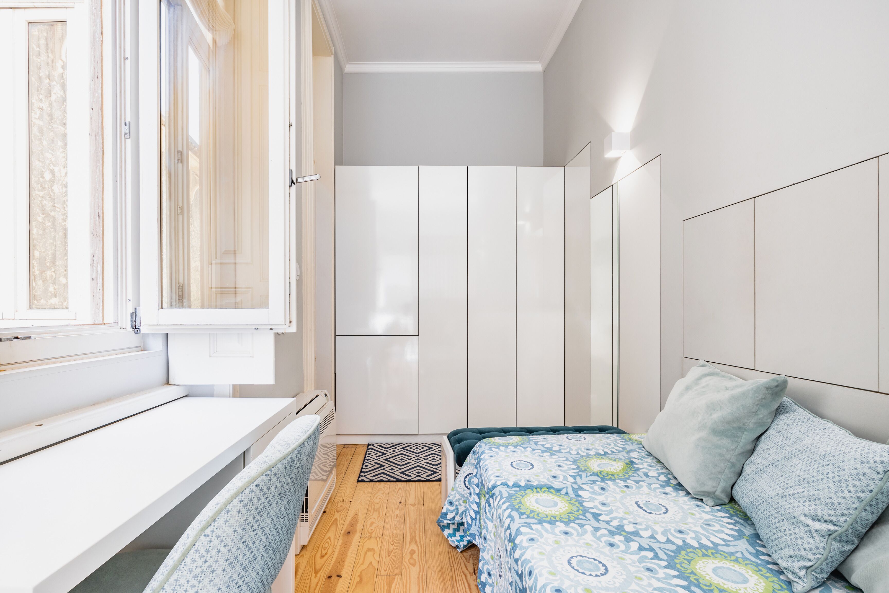 Une chambre à coucher avec un lit, un bureau et une armoire.