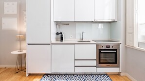 Een moderne keuken met witte kastjes, een roestvrijstalen oven en een spoelbak.