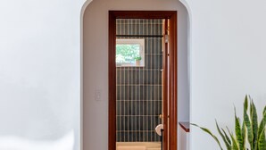 Ein Flur mit Holzboden, weißer Wand und einem Blumentopf.