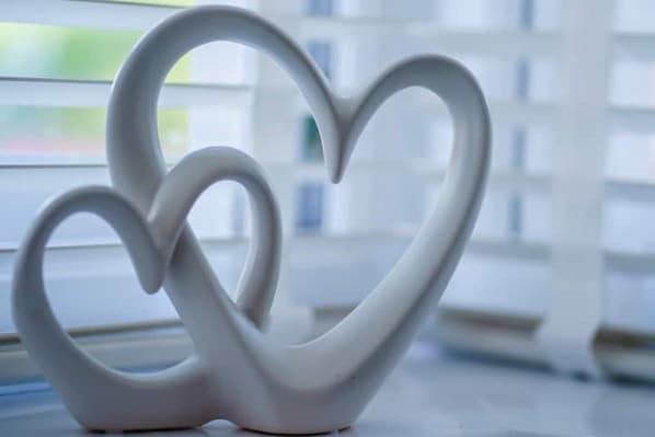 Una escultura con forma de corazón en una habitación con ventanas amplias.