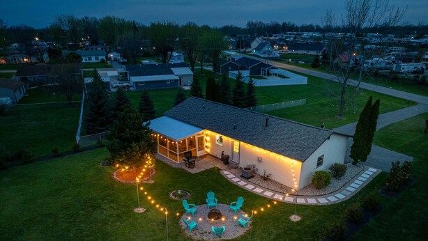 Une maison d’habitation dotée d’un patio, d’un éclairage extérieur et d’une pelouse.