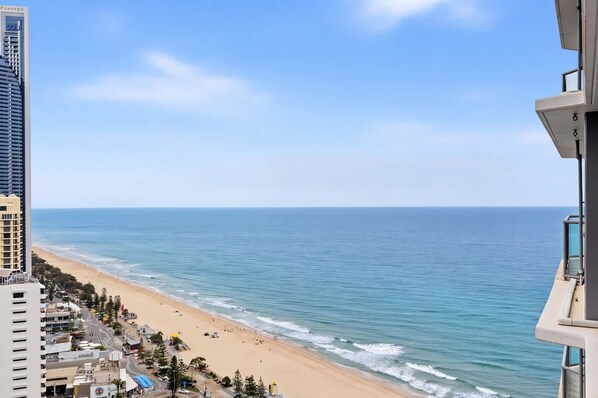 A coastal view with a beach, ocean, and buildings.