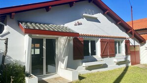 A white building with a red roof, a tiled roof, and a small balcony. - Superbe Maison - Biarritz/plage (Biarritz)